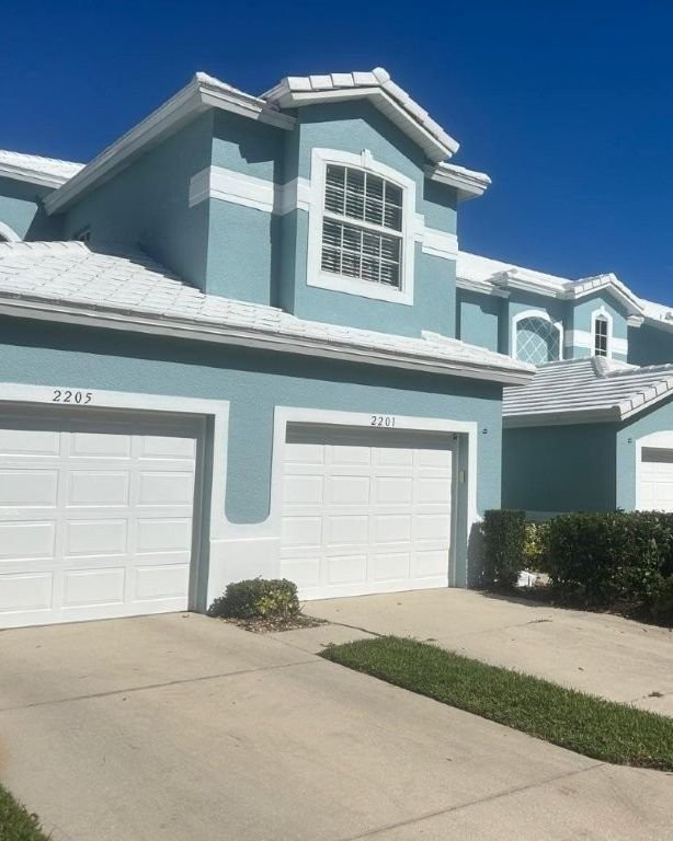 White tile roof replacement and exterior paint on townhomes in Naples, Florida by Expert Roofing Services